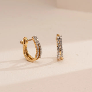 Top-down view of Reia’s 14 KT Yellow Gold Double Row Pavé Diamond Hoops. The layout highlights the architectural parallel bands and shimmering round-cut diamonds against a clean, cream backdrop.