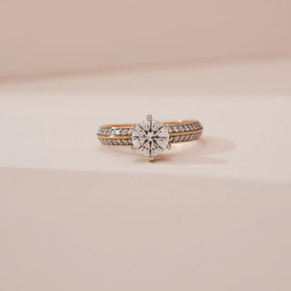 Front view of Reia’s 14 KT Yellow Gold Royal Pavé Diamond Solitaire Ring. Captured against a cream backdrop, the layout highlights the radiant glow of the round brilliant-cut centre diamond.