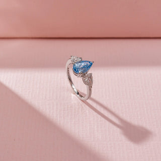 Angled view of Blue Pear-Shaped Diamond Ring in 14KT White Gold, featuring a blue pear-cut centre diamond and diamond side stones.