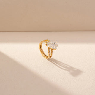 Angled view of Pear-Shaped Solitaire Diamond Ring in 14KT Yellow Gold, featuring a pear-cut lab-grown diamond and pavé bands.