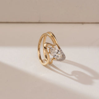 Side angle view of 14KT yellow gold wave ring featuring a marquise-cut centre diamond in a tension-style setting with a flowing multi-band design and pavé-set diamond accents.