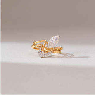 Front angle view of 14KT yellow gold wave ring featuring a marquise-cut centre diamond and layered flowing bands with pavé-set diamond accents along the lower curve.