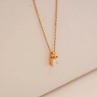 Side view of yellow gold solitaire pendant featuring a radiant-cut lab grown diamond in an open geometric setting, suspended from a fine gold chain against a soft neutral background.