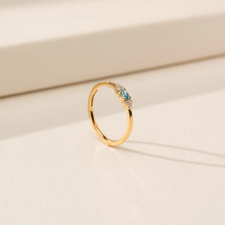 Angled view of Blue Diamond Ring in 14KT Yellow Gold, featuring a round blue diamond with round lab-grown diamond side stones.