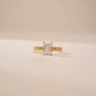 Front view of a 14KT Yellow Gold diamond ring, featuring an emerald-cut centre diamond and textured band.