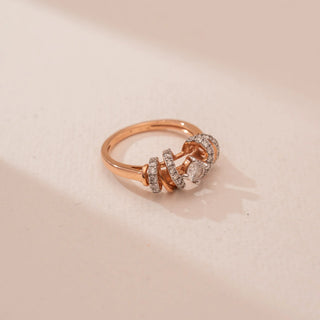 Top view of Reia’s 14 KT Rose Gold Radiant Curve Diamond Designer Ring. Lab-grown diamonds follow fluid, sculptural curves on a warm rose gold band, shown against a soft pink surface.