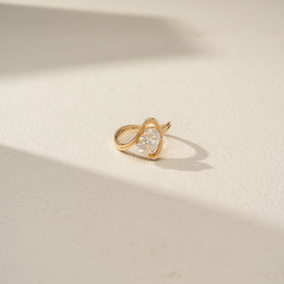 Top view of a contemporary yellow gold ring featuring an oval-cut solitaire diamond framed by a graceful crossover band, highlighting the sculptural design and sparkling center stone.