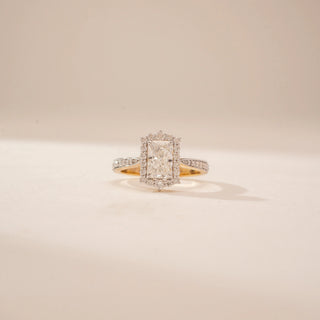 Front view of a 14KT Yellow Gold diamond ring, featuring an emerald-cut centre diamond and diamond halo.