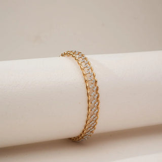 Close-up angled view of yellow gold diamond bangle featuring marquise leaf-inspired clusters formed with round lab-grown diamonds, elegantly placed on a soft neutral display surface.