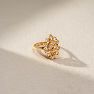 Side view of a floral diamond statement ring in 14 KT Yellow Gold, featuring round lab-grown diamonds arranged in an intricate fan-shaped floral motif with openwork detailing, displayed against a beige backdrop.