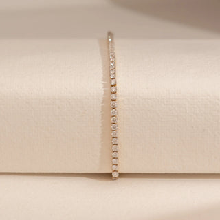 Front view of Reia’s 14 KT Yellow Gold Timeless Elegance Diamond Tennis Bracelet. The layout highlights the warm gold foundation and the brilliant natural fire of the diamond line.