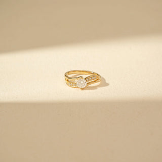 Close-up view  of Round Solitaire Diamond Ring in 14KT Yellow Gold, featuring a round diamond and double curved pavé bands.