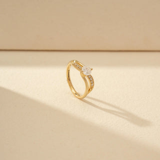 Angled view of Round Solitaire Diamond Ring in 14KT Yellow Gold, featuring a round diamond and double curved pavé bands.