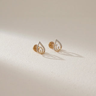 Front view of Twisted Teardrop Diamond Stud Earrings in 14KT Yellow Gold, featuring an open teardrop design with EF-VVS lab-grown diamonds, placed on a light textured surface with soft shadows.