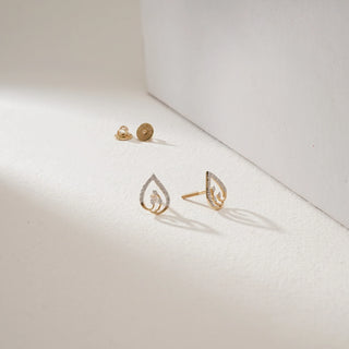 Twisted Teardrop Diamond Stud Earrings in 14KT Yellow Gold, placed on a light surface, featuring an open teardrop design with EF-VVS lab-grown diamonds and delicate Bombay screw backs.