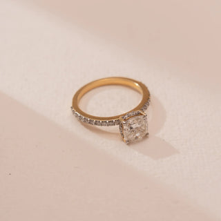 Top view of Reia’s 18 KT Yellow Gold Softglow Cushion Solitaire Diamond Ring, showing the round-cut diamond framed by a diamond-lined band. 