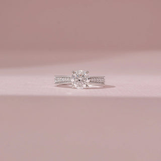 Front view of a 14KT White Gold diamond ring with a round centre stone and double pavé-set band.