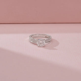 Close-up view of a 14KT White Gold diamond ring with a round centre stone and double pavé-set band.