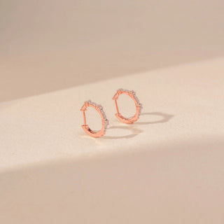 Side view of 14KT rose gold hoop earrings, featuring pavé-set round lab-grown diamonds along the front of each hoop.