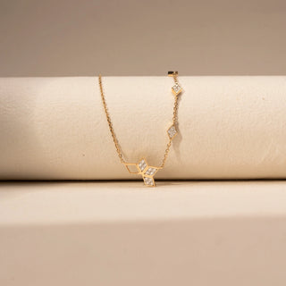 Front view of a geometric lab-grown diamond necklace in 14KT Yellow Gold, featuring open hexagonal motifs with bezel-set diamonds. Captured against a beige backdrop, the contemporary design exudes minimalist elegance.