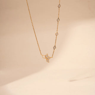 Front view of a geometric lab-grown diamond necklace in 14KT Yellow Gold, featuring open hexagonal motifs with bezel-set diamonds. Captured against a beige backdrop, the contemporary design exudes minimalist elegance.