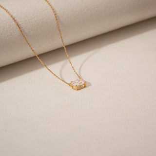 Top view of an oval-cut diamond pendant in 14KT Yellow Gold with a delicate gold chain and minimal setting.