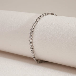 Constellation Tennis Diamond Bracelet in 14KT white gold with bezel-set lab-grown diamonds, angled side view against a soft beige background.