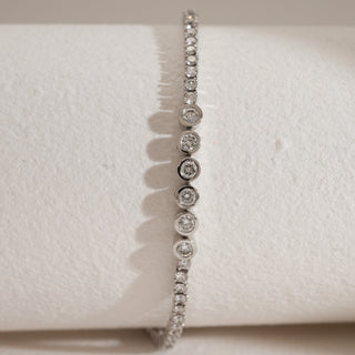 Close-up front view of Constellation Tennis Diamond Bracelet featuring bezel-set lab-grown diamonds, displayed on a soft beige background.