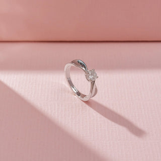 Angled view of Cushion Solitaire Diamond Ring in 14 KT white gold,  featuring a square-cut centre diamond and sleek twisted crossover shoulders.
