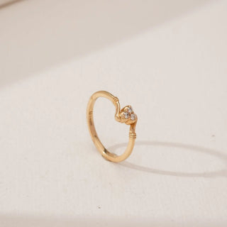 Side angled view of Golden Heart Trio Diamond Ring in yellow gold, showcasing a heart-shaped motif set with three round lab-grown diamonds on a slender polished band against a neutral background.