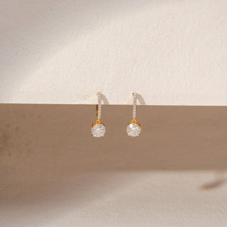 Front view of diamond drop earrings in 14KT yellow gold, featuring round lab-grown diamonds and pavé accents.