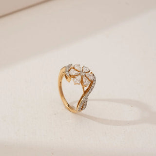 Angled front view of Pear Petal Cluster Diamond Ring in yellow gold, showcasing pear-shaped lab-grown diamonds forming a floral cluster with a diamond-lined bypass band against a neutral backdrop.