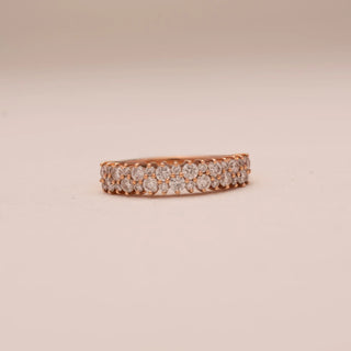 Front view of Reia’s 14 KT Rose Gold Eternal Glow Band. The centred row of radiant, pavé-set round diamonds is showcased against a soft pink surface, highlighting its continuous sparkle.