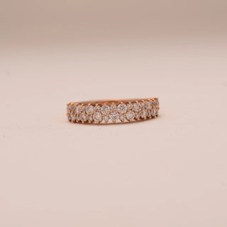 Front view of Reia’s 14 KT Rose Gold Eternal Glow Band. The centred, uniform row of pavé-set round diamonds is showcased against a soft pink surface, highlighting its seamless brilliance.