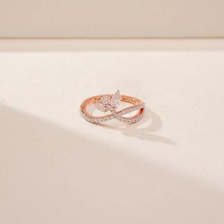 Close-up view of a 14KT Rose Gold diamond ring with a butterfly motif and pavé-set crossover band.