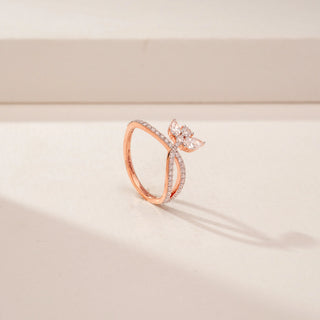Angled view of a 14KT Rose Gold diamond ring with a butterfly motif and pavé-set crossover band.