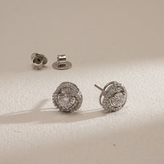 Angled view of Cluster Halo Diamond Stud Earrings photographed on beige background. Made in 14KT hallmarked white gold with bombay screw backs. Diamonds are EF VVS lab grown, total 1.42 carats with a 0.47-carat solitaire. Product weight 3.43 grams, falls in INR 50,000–1,00,000 price range.