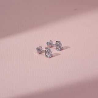 Top view of pear-shaped lab-grown diamond stud earrings in 14 KT white gold, featuring three-prong pear-cut solitaire diamonds with open basket settings in a timeless elegant design.