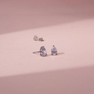 Angled view of pear-shaped lab-grown diamond stud earrings in 14 KT Yellow gold, featuring three-prong pear-cut solitaire diamonds with open basket settings in a timeless elegant design.