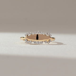 Front view of oval halo diamond ring in yellow gold, featuring an open oval centre framed by round lab-grown diamonds along the edges. Set on a soft neutral backdrop, it reflects minimal elegance and airy sparkle.