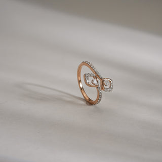 Side view of Infinity Embrace Diamond Promise Ring in 14KT Rose Gold, featuring twin pear-shaped lab-grown diamonds and a diamond-studded band, displayed on a soft neutral surface.