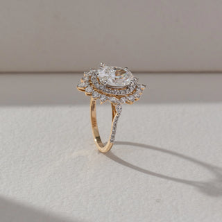 Side view of Vintage Halo Diamond Ring in 14KT Yellow Gold, featuring an oval lab grown diamond with halo and marquise accents. Set on a beige backdrop, the design highlights structure and intricate brilliance.
