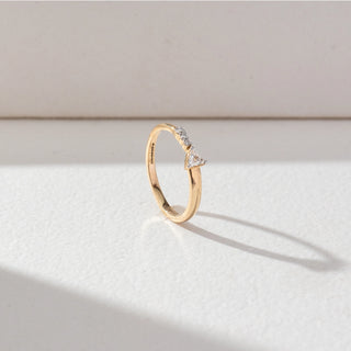Side view of Round Accent Diamond Ring in 14KT Yellow Gold, featuring a centred trillion-cut lab grown diamond with round accent stones. Set on a beige backdrop, the design highlights structure and minimal elegance.
