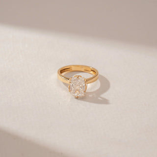 Close-up view of a 14KT Yellow Gold ring featuring a cushion diamond in a four-prong setting with a polished gold band.