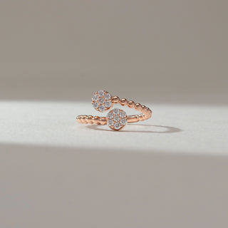 Front view of open bead diamond ring in rose gold, featuring two circular cluster heads set with round lab-grown diamonds on a beaded band. Set on a soft neutral backdrop, it reflects playful sparkle and elegance.
