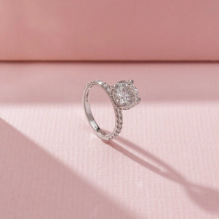 Angled view of 14 KT White Gold Round Solitaire Diamond Ring , featuring a round lab-grown diamond and pavé diamond band.