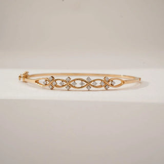 Front view of yellow gold infinity wave diamond bracelet with interlaced loops accented by round lab-grown diamonds, displayed on a clean neutral surface highlighting its flowing design.