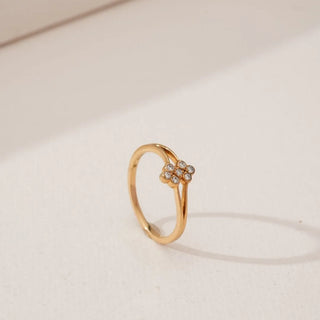 Side angled view of Petite Golden Cluster Diamond Ring in yellow gold, highlighting a floral cluster of round lab-grown diamonds set on a slender split band against a soft neutral background.