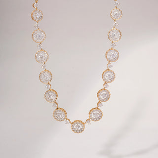 Front view of a floral lab-grown diamond necklace in 14KT Yellow Gold, featuring round diamond cluster motifs linked by bezel-set accents. Captured against a beige backdrop, the elegant design radiates timeless brilliance.