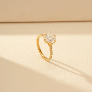 Angled view of Classic Solitaire Diamond Ring in 14KT Yellow Gold, featuring a round brilliant-cut diamond and pavé-set band.